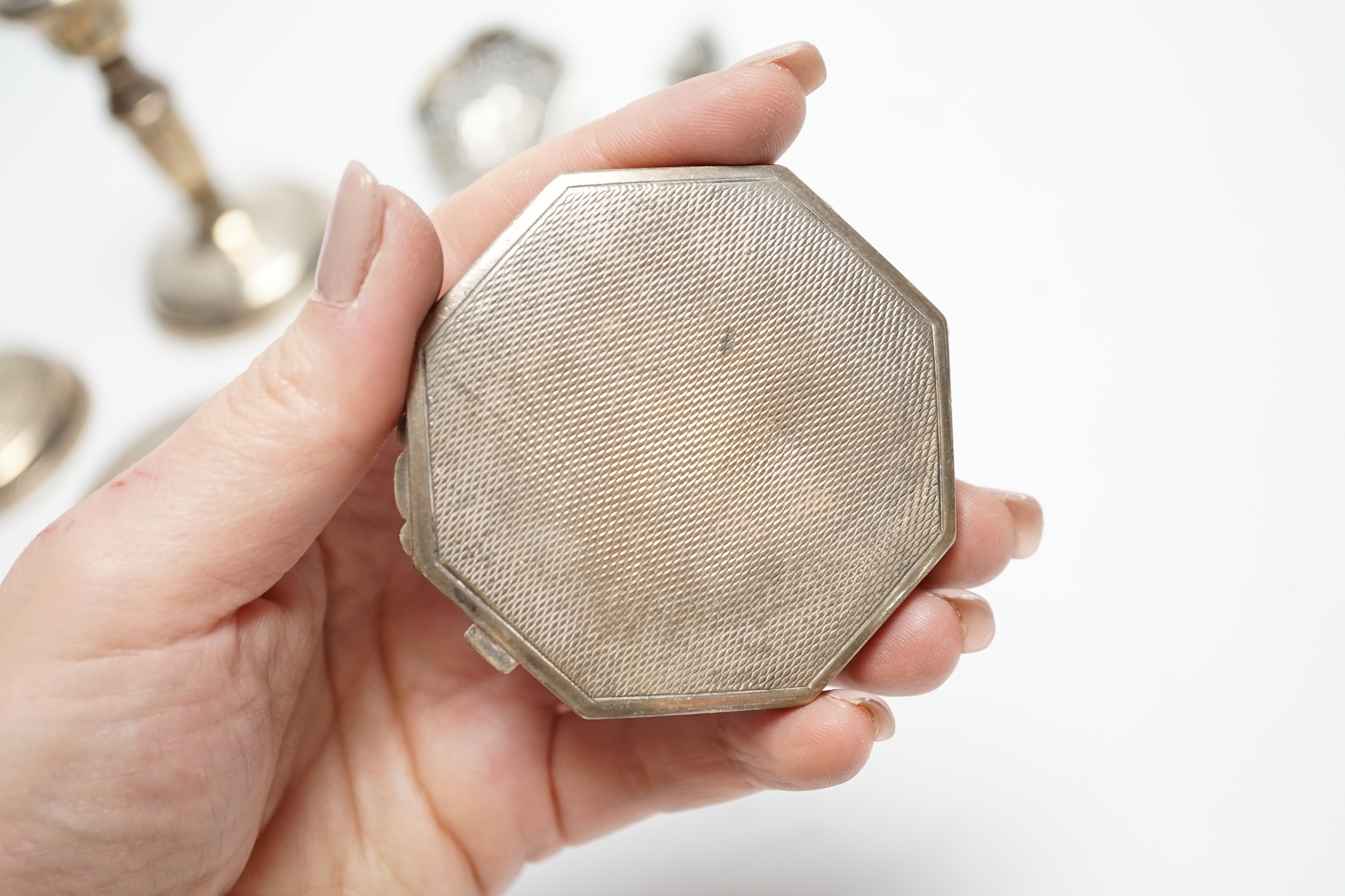 Three silver compacts including one enamelled, a pair of silver mounted dwarf candlesticks, 10.2cm and two other items.